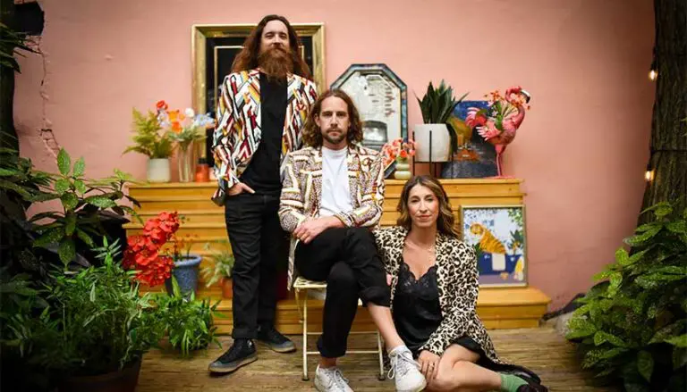 damn tall buildings band members posing among plants and art 768x439