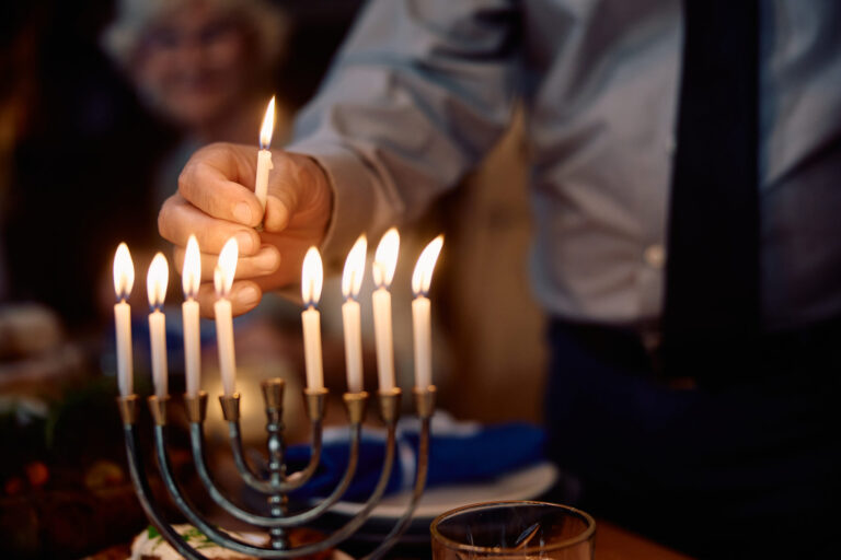 close up of senior jewish man lights the menorah a 2023 11 27 04 54 07 utc scaled 1 768x512