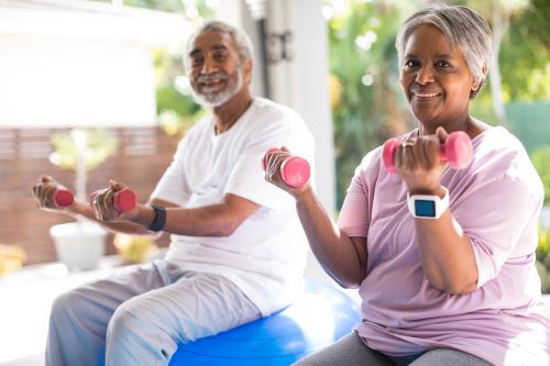 Couple seated and lifting dumbbells